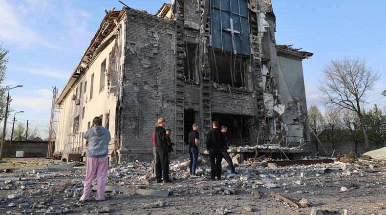 People stand outside a Baptist church damaged by a Russian guided aerial bomb, in Zaporizhzhia, Ukraine, Thursday, April 16, 2026. (AP Photo/Kateryna Klochko)