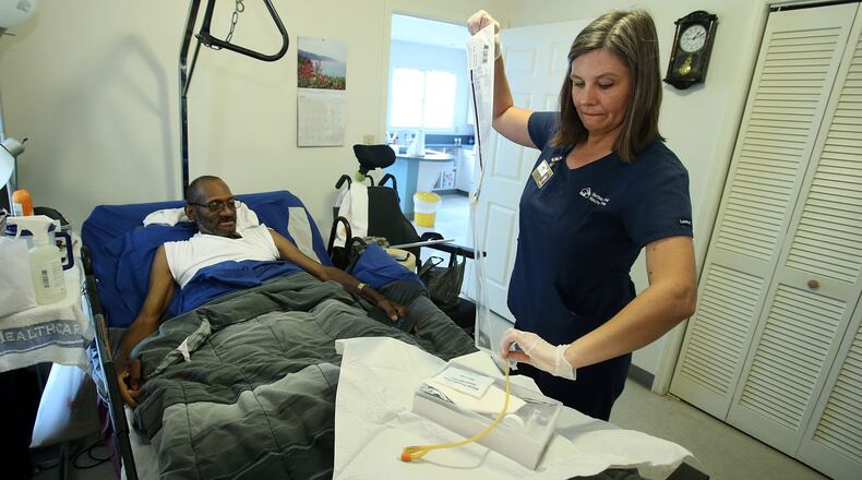 Lynn Adams cares for patient Willie Peterson II, who was paralyzed from the waist down by a falling tree in 1998 and needs regular skilled medical attention.