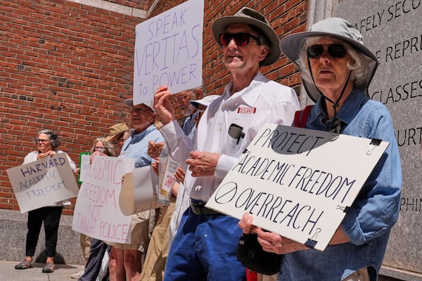 Protestors gather outside the Moakley Federal Courthouse, where Harvard University appeared to challenge $2.6 billion in funding cuts by the Trump administration, Monday, July 21, 2025, in Boston. (AP Photo/Charles Krupa)