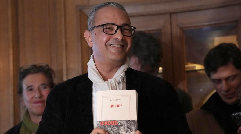FILE - Algerian-French novelist Kamel Daoud holds his book Houris after being awarded with the Goncourt, France's most prestigious literary prize, Monday, Nov. 4, 2024 in Paris. (AP Photo/Aurelien Morissard, File)