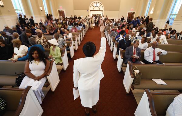 Usher Jazmine Frear directs parishioners to their seats as members attend the first morning worship service at Friendship Baptist Church Sunday, July 30, 2017. 