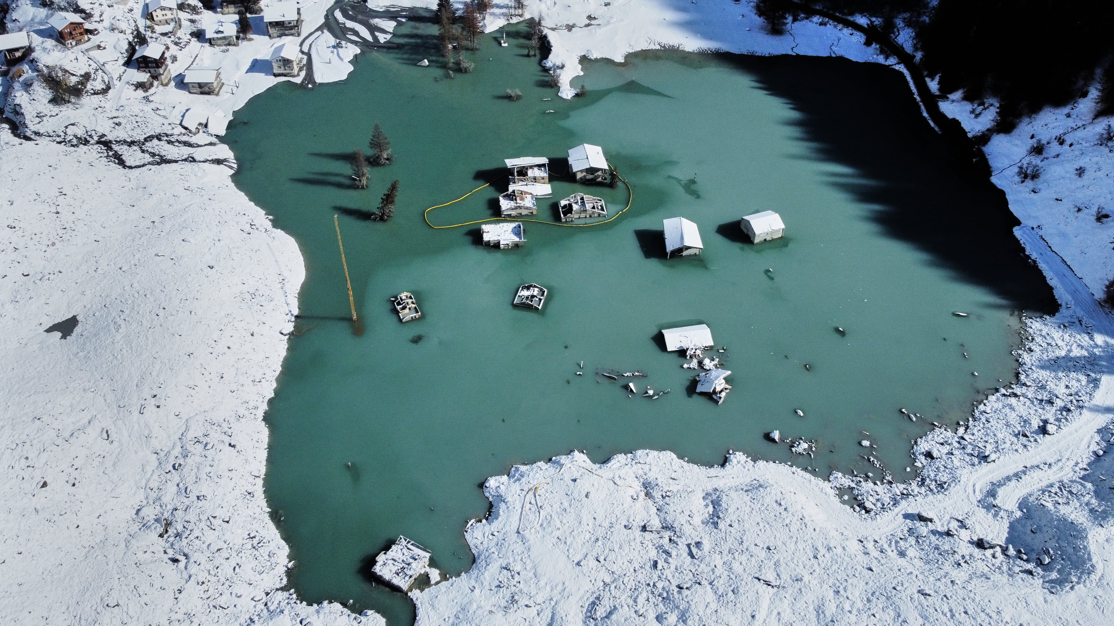 An aerial view shows the partly flooded village of Blatten after recent snowfalls, five months after a landslide destroyed the village, Blatten, Switzerland, on Tuesday, Oct. 28, 2025. (AP Photo/Michael Probst)