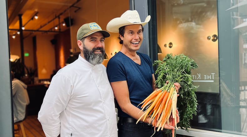 Chef Michael Bertozzi and Kimbal Musk stand in front of The Kitchen, a chain of restaurants co-founded by Musk, based in Boulder, Colo. Musk and Bertozzi, a former executive chef at TWO Urban Licks, visited Atlanta March 14, 2024, for a book-signing event on the release of Musk's first cookbook, "The Kitchen Cookbook," at Virginia Highland Books.