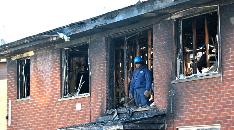 A Detroit Fire Department investigator stands on the second floor after a deadly fire at an apartment complex Wednesday, March 8, 2016, in Detroit. (Todd McInturf/Detroit News via AP)