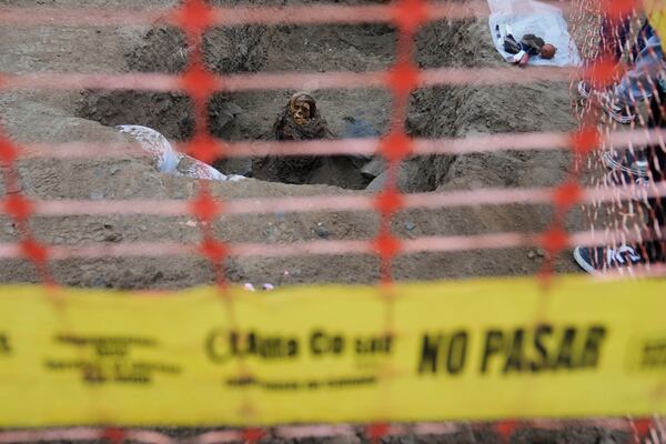 An ancient mummy which archeologists identify as female and from the pre-Inca Chancay culture is partially excavated after being discovered by city workers digging a natural gas line for the company Calidda in the district of Puente Piedra on the outskirts of Lima, Peru, Wednesday, June 18, 2025. (AP Photo/Martin Mejia)