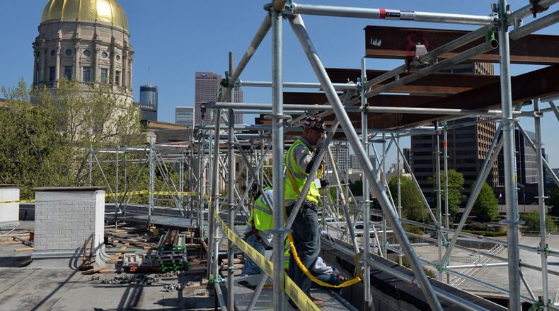 Workers replace exterior stone work on the old DOT building across Capitol Square from the Capitol Thursday, April 17, 2014. Money for the renovations that will convert the building into office space for the state Office of Planning and Budget will come from the 2015 fiscal year budget.
