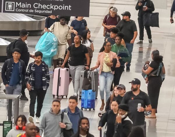 Passengers walk through Hartsfield-Jackson International Airport on Friday morning. Hartsfield-Jackson had a record number of passengers at security checkpoints as Memorial Day travel ramps up. 