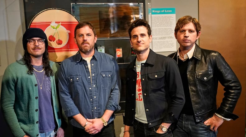 Rockers Kings of Leon, from left, Nathan, Caleb, Jared, and Matthew Followill, pose for a photo in front of their exhibit at the Rock and Roll Hall of Fame Thursday, April 29, 2021, in Cleveland. The band toured a new digital exhibit at the Rock and Roll Hall of Fame for the NFT (non-fungible token) launching before the rock band plays at the NFL draft, Thursday, April 29, 2021, in Cleveland. from left, Nathan, Caleb, Jared, and Matthew Followill are shown. (AP Photo/Tony Dejak)