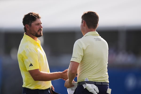 Andrew Novak, left, shakes hands with teammate Ben Griffin on the 18th green after finishing the first round of the PGA Zurich Classic golf tournament at TPC Louisiana in Avondale, La., Thursday, April 24, 2025. (AP Photo/Gerald Herbert)