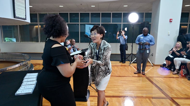 Myeong Hwa Jang reacts as she receives her certificate from Jessica Stewart, left, Community Outreach Program Manager, during Gwinnett 101 Citizens Academy's Spring 2021 graduation ceremony at Gwinnett Justice & Administration Center on Tuesday, June 22, 2021. (Hyosub Shin / Hyosub.Shin@ajc.com)