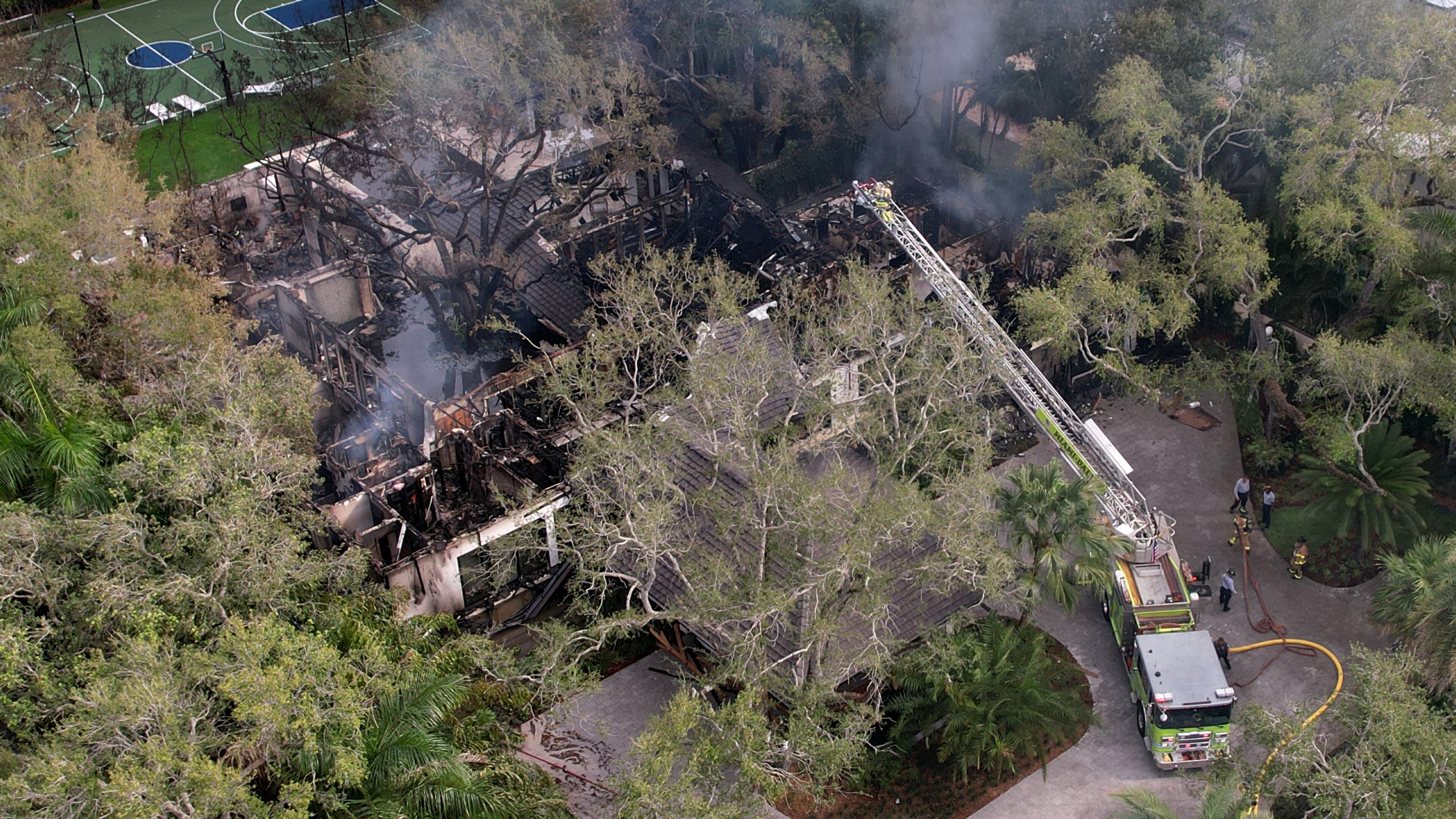 Firefighters work to extinguish the remains of a fire at a home owned by Miami Heat basketball coach Erik Spoelstra, Thursday, Nov. 6, 2025, in Miami. (AP Photo/Rebecca Blackwell)