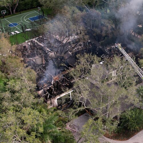 Firefighters work to extinguish the remains of a fire at a home owned by Miami Heat basketball coach Erik Spoelstra, Thursday, Nov. 6, 2025, in Miami. (AP Photo/Rebecca Blackwell)