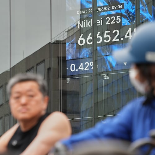 People stop in front of an electronic stock board showing Japan's Nikkei index at a securities firm Tuesday, June 2, 2026, in Tokyo. (AP Photo/Eugene Hoshiko)