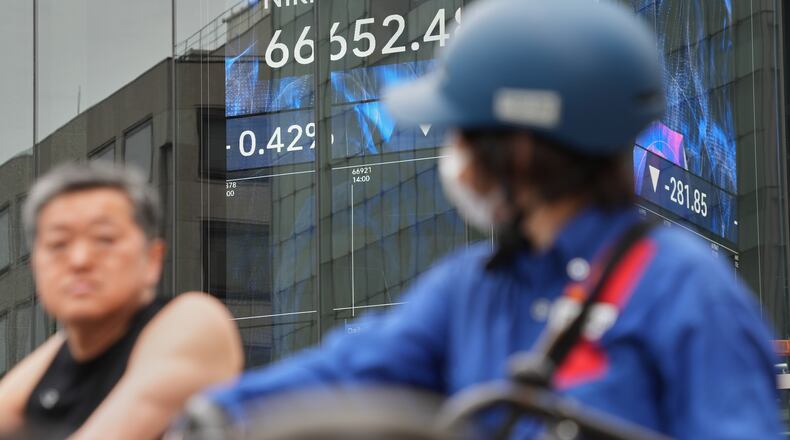 People stop in front of an electronic stock board showing Japan's Nikkei index at a securities firm Tuesday, June 2, 2026, in Tokyo. (AP Photo/Eugene Hoshiko)