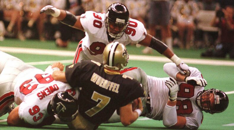Atlanta defensive end Chuck Smith (90) assists teammates Dan Owens (93) and Travis Hall (98) in bringing down Saints quarterback Danny Wuerffel during the Falcons 23-17 win at the Louisiana Superdome in New Orleans Sunday Oct. 12, 1997.