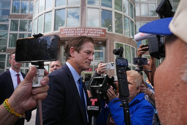 Los Angeles County District Attorney Nathan Hochman is surrounded by media outside the Van Nuys Courthouse during a hearing in the case of Erik and Lyle Menendez Tuesday, May 13, 2025, in Los Angeles. (AP Photo/Damian Dovarganes)