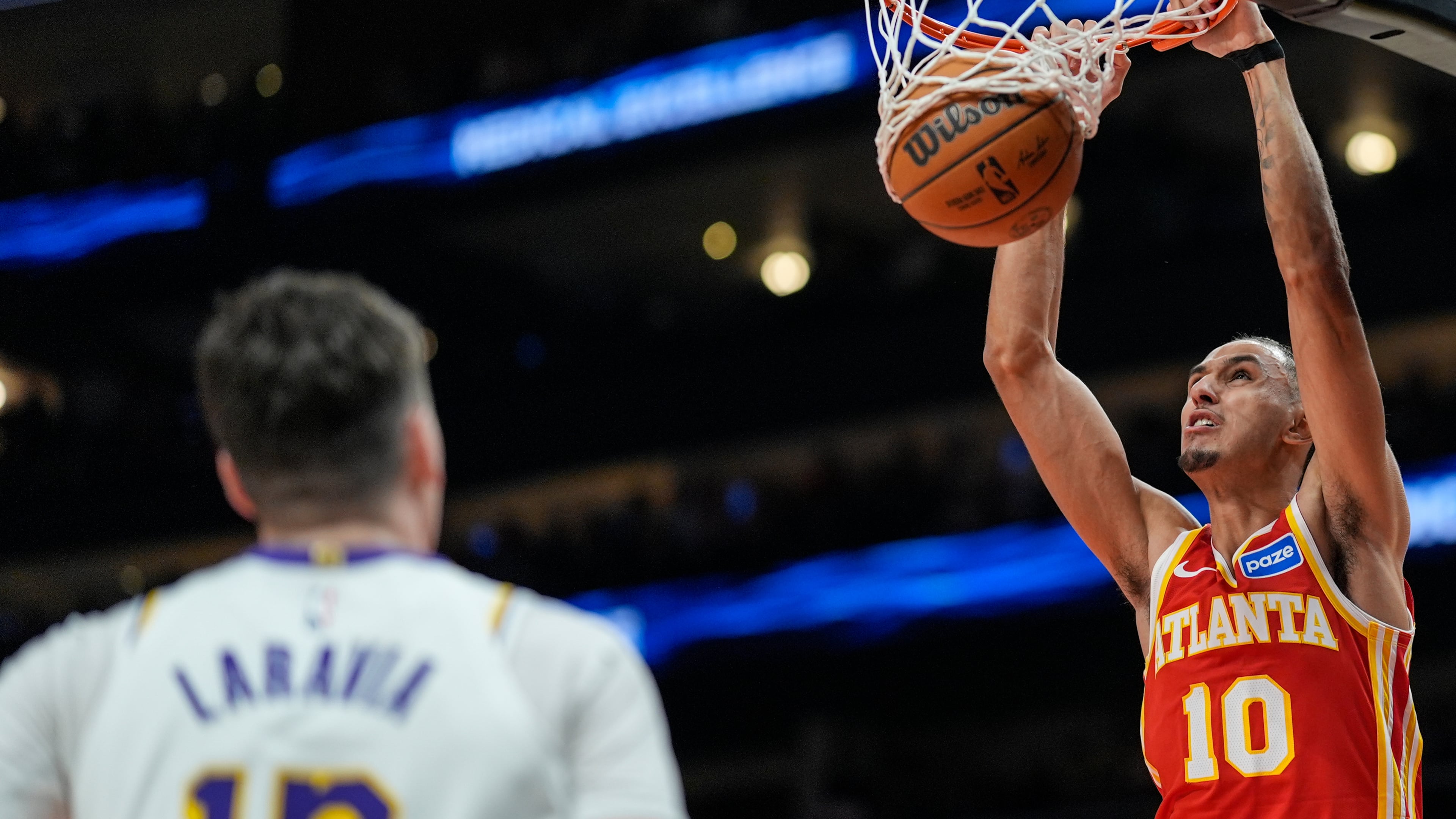 Atlanta Hawks forward Zaccharie Risacher (10) dunks against Los Angeles Lakers forward Jake LaRavia (12) during the first half of an NBA basketball game, Saturday, Nov. 8, 2025, in Atlanta. (AP Photo/Mike Stewart)