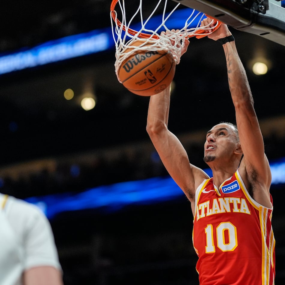 Atlanta Hawks forward Zaccharie Risacher (10) dunks against Los Angeles Lakers forward Jake LaRavia (12) during the first half of an NBA basketball game, Saturday, Nov. 8, 2025, in Atlanta. (AP Photo/Mike Stewart)