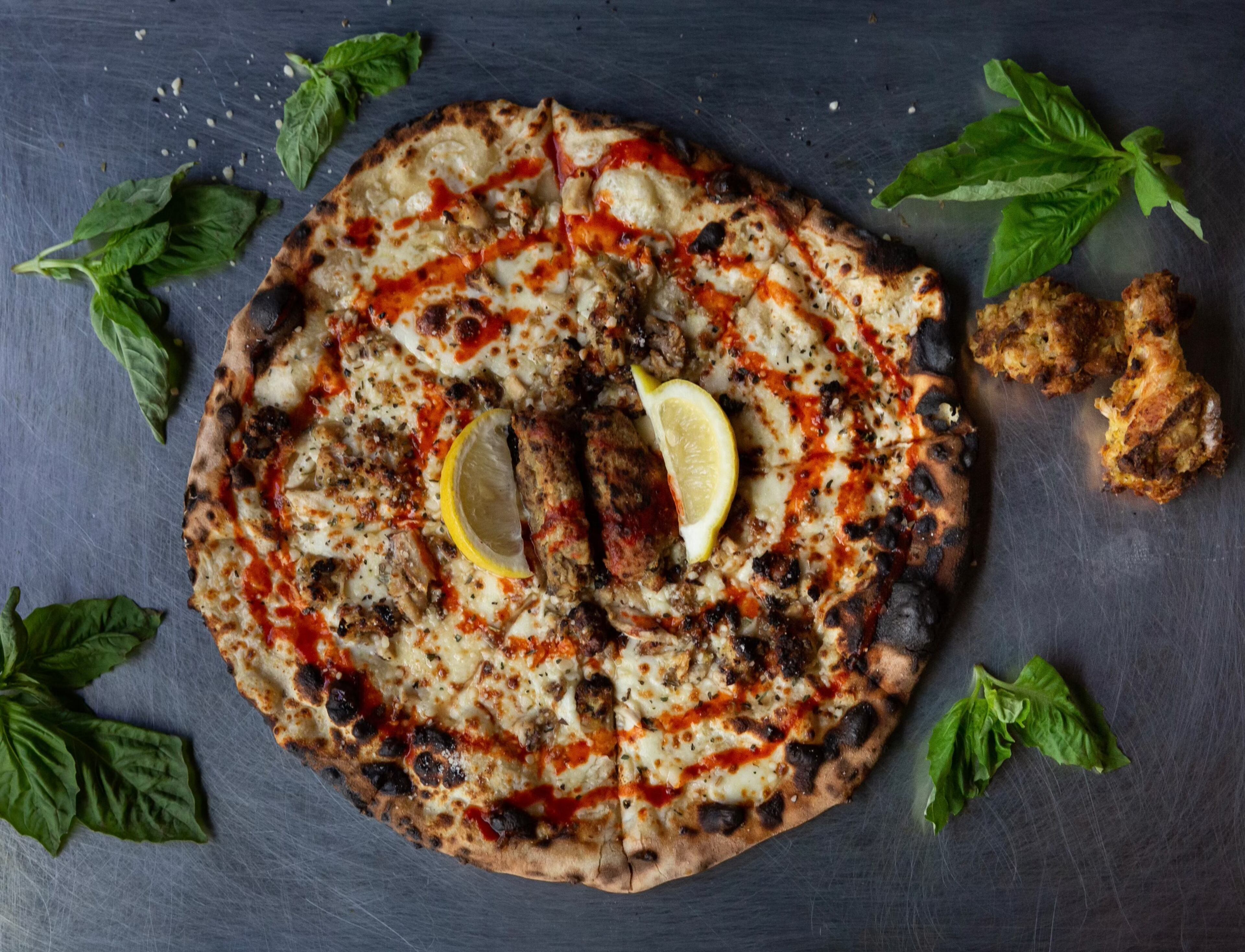 Atlanta native Matthew Foster wanted to create a pizza that pays tribute to Atlanta culture. His solution was to add lemon-pepper sauce and a couple of wet, lemon-pepper wing flats. Behold, Phew’s Pies’ Hot Lemon Pepper Wet pie. (Courtesy of Drew Amandolia)