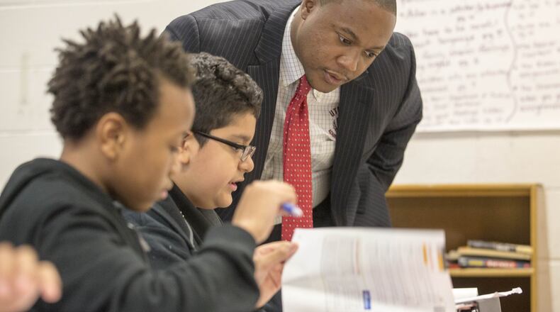 Utopian Academy for the Arts founder and executive director Artesius Miller goes over classwork with a student at the school in Ellenwood, Thursday, September 27, 2018. (ALYSSA POINTER/ALYSSA.POINTER@AJC.COM)