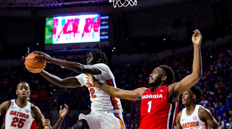 Florida forward Isaiah Stokes (2) grabs a rebound next to Georgia's Yante Maten during the first half of an NCAA college basketball game Wednesday, Feb. 14, 2018, in Gainesville, Fla.