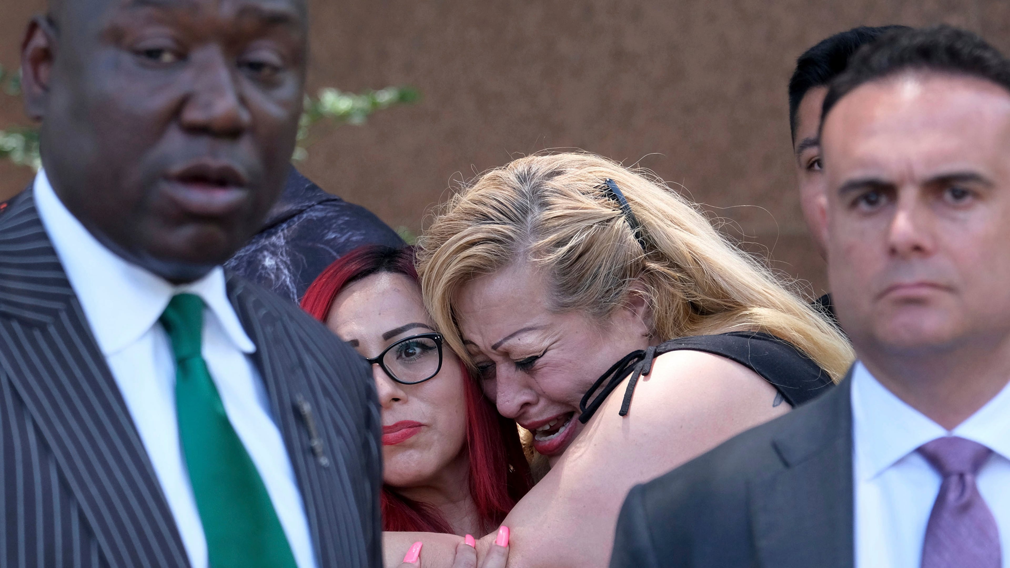 FILE - Nicole Castro cries as she hugs Janet Rameriz behind attorneys Ben Crump, left, and Adam Slater during a press conference with survivors of sexual abuse that occurred at MacLaren Hall, June 9, 2022 in Los Angeles. (Dean Musgrove/The Orange County Register via AP, File)