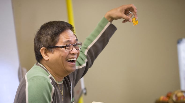Age Well Senior Services activity coordinator Reggie Tamon engages a group of seniors during adult day care in Laguna Woods, CA in 2011.