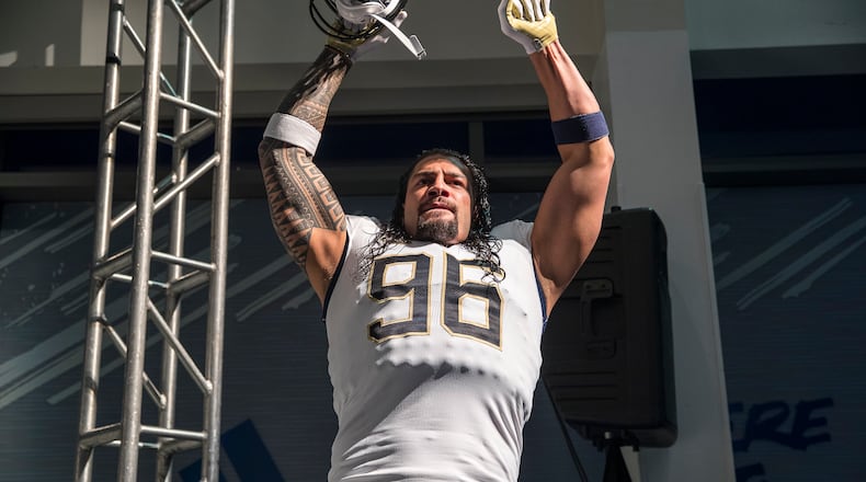 Professional wrestler and former Georgia Tech football player Roman Reigns models the new football uniforms during a reveal party in Atlanta, Friday, August 3, 2018.  (ALYSSA POINTER/ALYSSA.POINTER@AJC.COM)