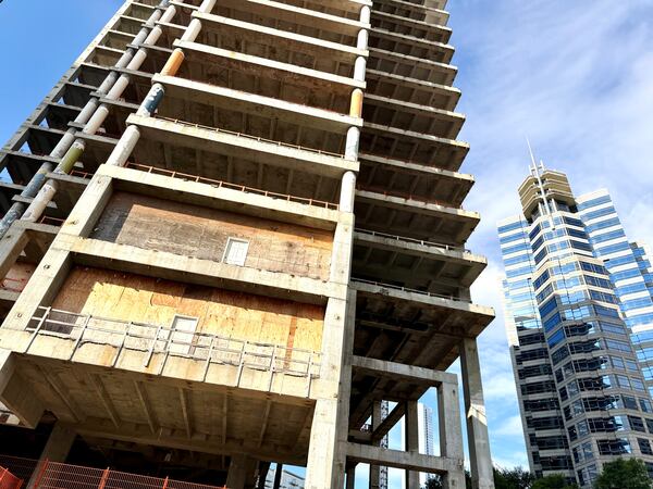 The Campanile building, left, at the corner of Peachtree and 14th streets as seen on Thursday, Sept. 10, 2026. Exposed floors of the vacant tower, which developer John Dewberry has dubbed The Midtowne, contrast with occupied office towers in Midtown such as Proscenium, right. (J. Scott Trubey/AJC)