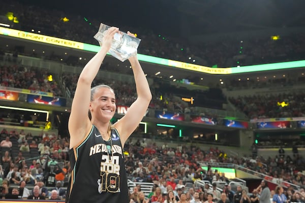 New York Liberty's Sabrina Ionescu holds the trophy after winning the 3-point contest at the WNBA All-Star basketball weekend, Friday, July 18, 2025, in Indianapolis. (AP Photo/Michael Conroy)