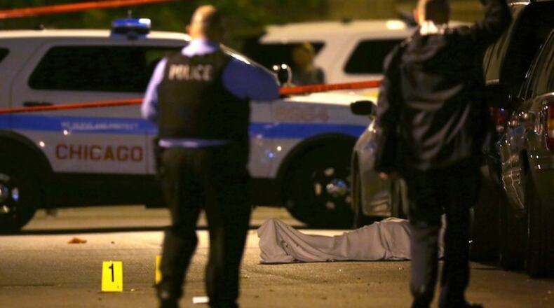 In this May 30, 2016, file photo, police work the scene where a man was fatally shot in the chest in Chicago's Washington Park neighborhood. Trump tweeted Tuesday, Jan. 24, 2017: "If Chicago doesn't fix the horrible 'carnage' going on, 228 shootings in 2017 with 42 killings (up 24% from 2016), I will send in the Feds!" The numbers were slightly different from the latest tally by the Chicago Police Department. As of Tuesday, police said, 234 people have been shot in 2017, including 38 who died. At this point last year, 227 people had been shot, including 33 deaths. (E. Jason Wambsgans/Chicago Tribune via AP, File)