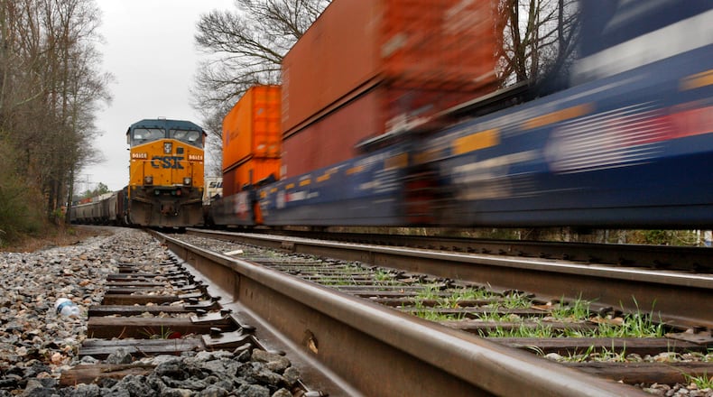 FILE PHOTO: A CSX train is stationary (left) as another train passes at the Stanley Road crossing in Kennesaw. (John Spink, jspink@ajc.com)