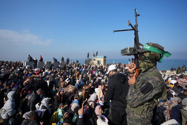 FILE - A Hamas fighter lifts his weapon as displaced Palestinians return to their homes in the northern Gaza Strip, Monday, Jan. 27, 2025. (AP Photo/Abdel Kareem Hana, File)