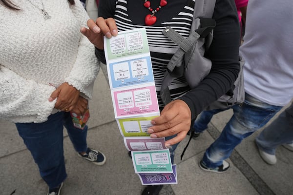 A supporter of Lenia Batres, who is running for election for the Mexican Supreme Court, holds an instruction sheet on how to vote, during her closing campaign rally in Mexico City, Wednesday, May 28, 2025. (AP Photo/Fernando Llano)