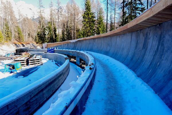 FILE - Construction work takes place at the Cortina Sliding Center, venue for the bob, luge and skeleton disciplines at the Milan Cortina 2026 Winter Olympics, in Cortina d'Ampezzo, Italy, Thursday, Jan. 16, 2025. (AP Photo/Giovanni Auletta, file)