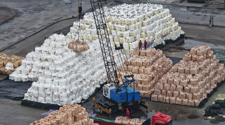 Workers transfer bags of imported solid sulfur onto a truck in a port in Nanjing in eastern China's Jiangsu province, Tuesday, April 14, 2026. (Chinatopix Via AP) CHINA OUT