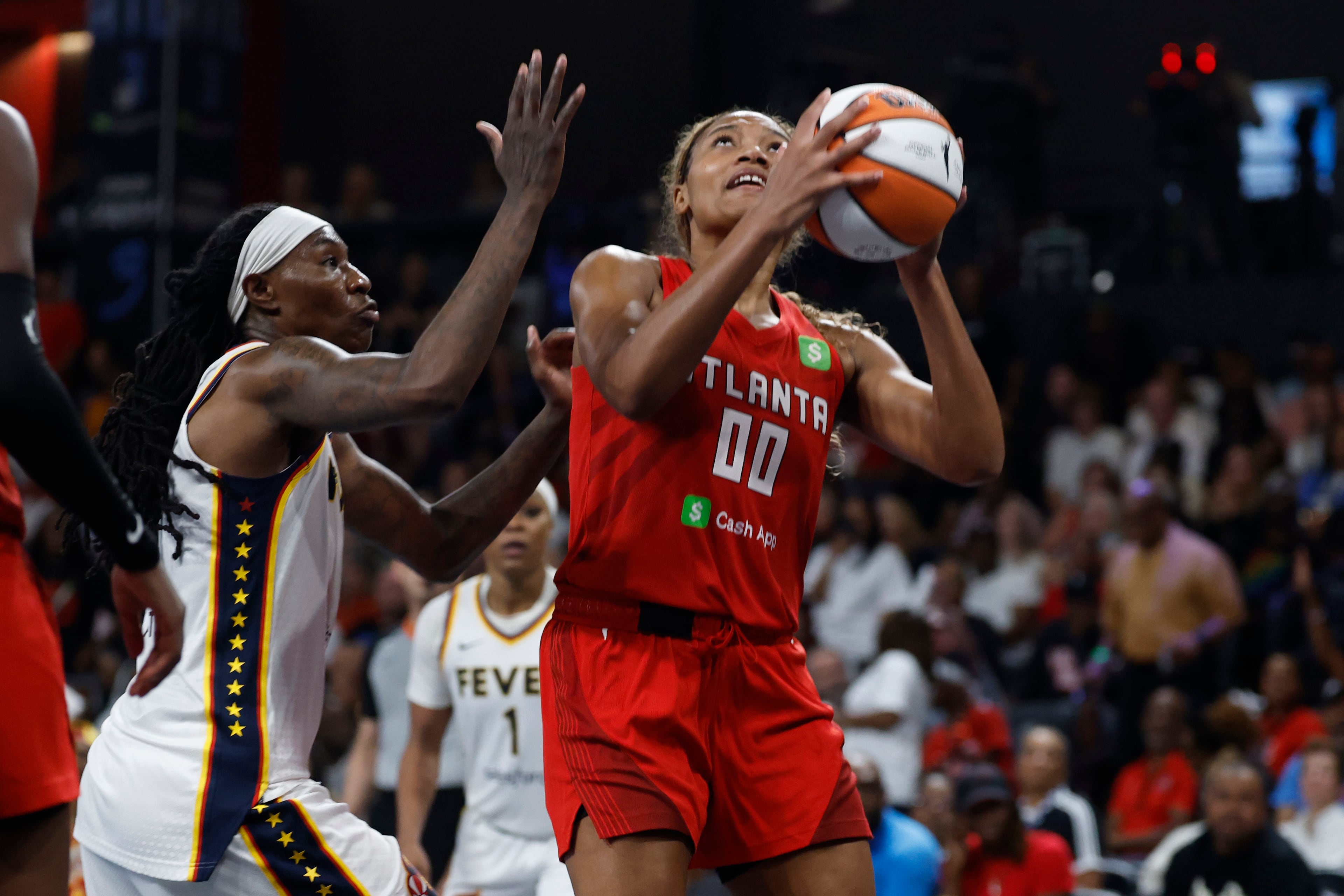 Atlanta Dream forward Naz Hillman (00) looks to shoo as Indiana Fever forward Natasha Howard, left, defends during the second half of Game 3 in the first round of the WNBA basketball playoffs, Thursday, Sept. 18, 2025, in Atlanta. (AP Photo/Butch Dill)