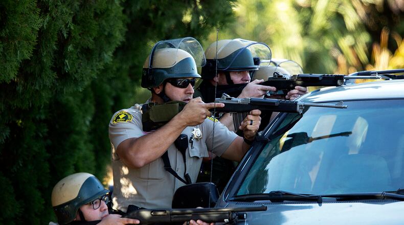 Police hunting for the attackers riddled a black SUV with gunfire several miles away from the scene of the mass shooting Wednesday. Gina Ferazzi / Los Angeles Times