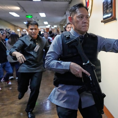Senate security run after gunfire was heard along a hallway at the Philippine Senate in Pasay, Philippines, Wednesday, May 13, 2026. (AP Photo/Aaron Favila)