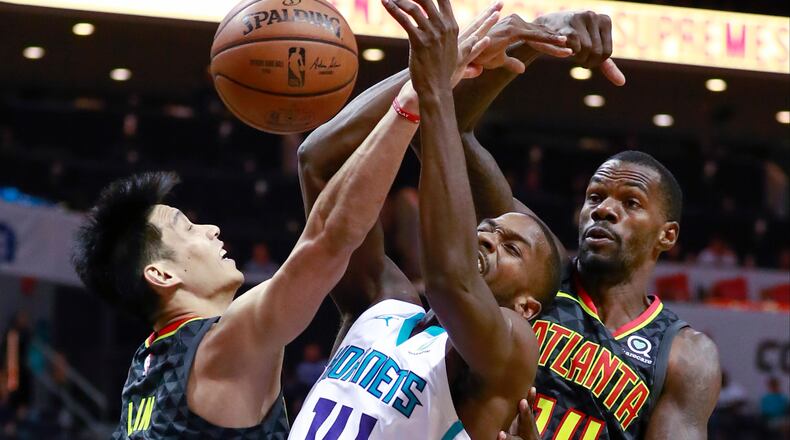 Charlotte Hornets forward Michael Kidd-Gilchrist (14) battles Atlanta Hawks' Jeremy Lin, left, and Dewayne Dedmon, right, for the basketball. (AP Photo/Jason E. Miczek)