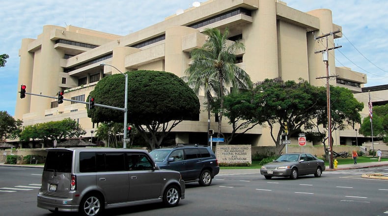 FILE - Cars pass in front of the federal building housing the U.S. District Court in Honolulu on March 7, 2014. (AP Photo/Jennifer Sinco Kelleher, File)