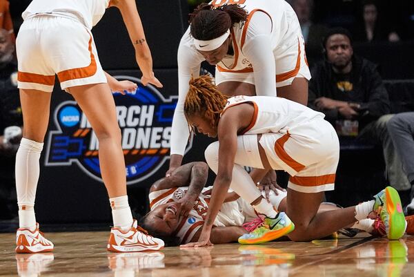 Texas guard Rori Harmon (3) is tended to by teammates after being fouled during the first half against Tennessee in the Sweet 16 of the NCAA college basketball tournament, Saturday, March 29, 2025. in Birmingham, Ala. (AP Photo/Gerald Herbert)
