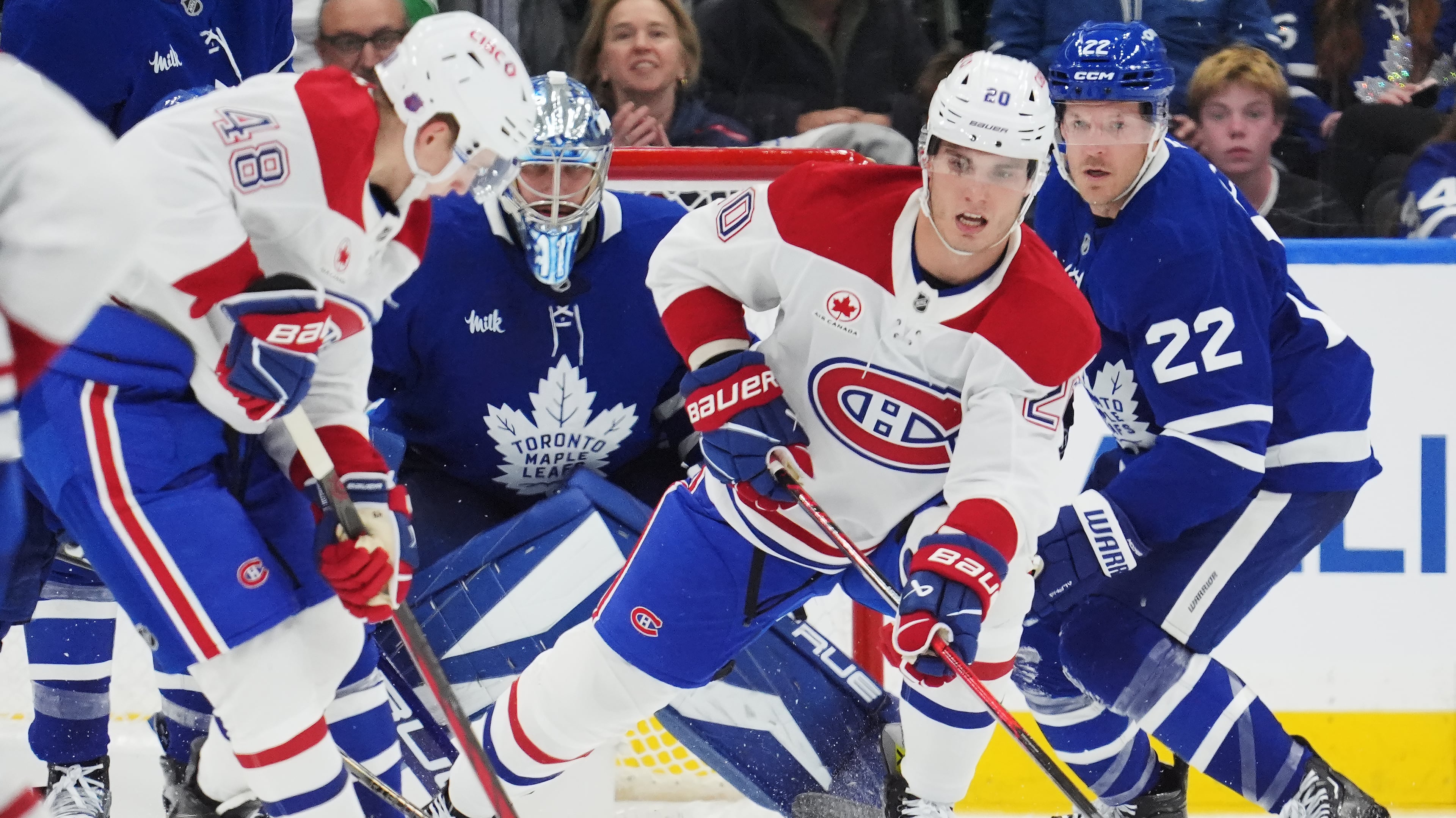 Montreal Canadiens' Lane Hutson (48) and Juraj Slafkovsky (20) work for the puck as Toronto Maple Leafs goaltender Anthony Stolarz (41) and Jake McCabe (22) look on during second period NHL hockey action in Toronto on Wednesday, Oct. 8, 2025. (Frank Gunn/The Canadian Press via AP)