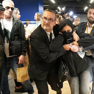 A protester is being evacuated from the BHV department store as fast fashion Shein opens its first physical store, Wednesday, Nov. 5, 2025 in Paris. (AP Photo/Thibault Camus)