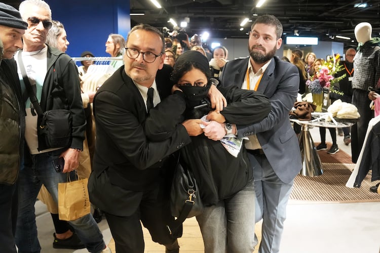 A protester is being evacuated from the BHV department store as fast fashion Shein opens its first physical store, Wednesday, Nov. 5, 2025 in Paris. (AP Photo/Thibault Camus)