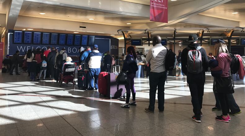 A line of passengers wait for Delta customer service at Hartsfield-Jackson on Saturday morning.