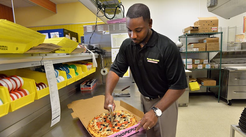 Preston Starr prepares a pizza for delivery at his Hungry Howie’s Pizza in Douglasville in this 2013 photo. He was seeking a loan backed by the Small Business Administration for a second restaurant in Smyrna, which he opened in 2014. This year, the SBA said it backed a record $1.4 billion in loans in Georgia. HYOSUB SHIN / HSHIN@AJC.COM