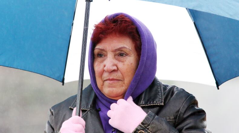Sabrinana Calderon braves the cold rain in DeKalb County Friday morning. The National Weather Service said early Friday that areas of the state along and south of a line from Warrenton to Americus would have the greatest chance for strong to severe storms Saturday afternoon.