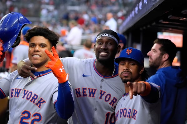 New York Mets' Juan Soto, left, Ronny Mauricio, middle, and Francisco Lindor, right, celebrate Soto's solo home run in the first inning of a baseball game against the Atlanta Braves, Tuesday, June 17, 2025, in Atlanta. (AP Photo/Brynn Anderson)