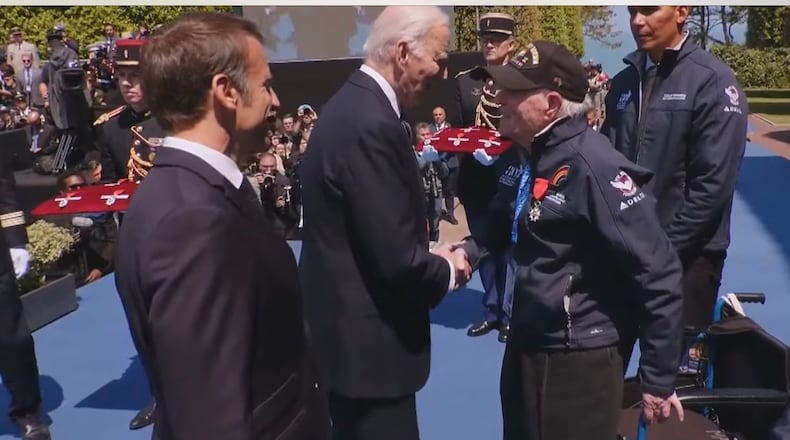 President Joe Biden meets Hilbert Margol, a 100-year-old World War II vet, at a ceremony in Normandy commemorating D-Day.  French President Emmanuel Macron is in foreground.